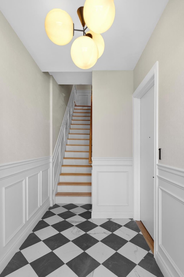 stairs featuring a decorative wall and a wainscoted wall