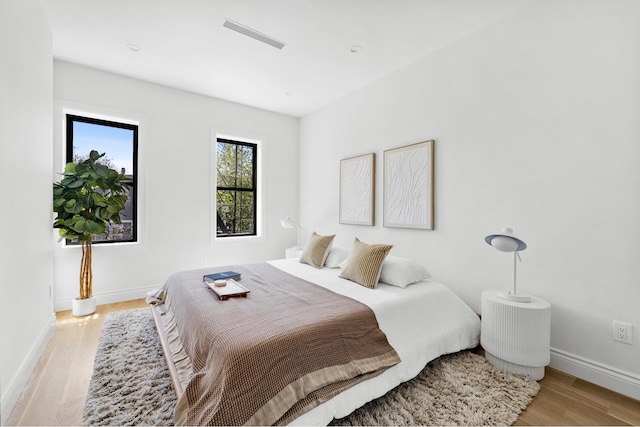 bedroom with light wood-type flooring and baseboards
