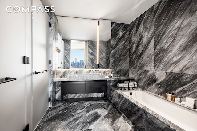 bathroom featuring a bath, a city view, vanity, and marble finish floor
