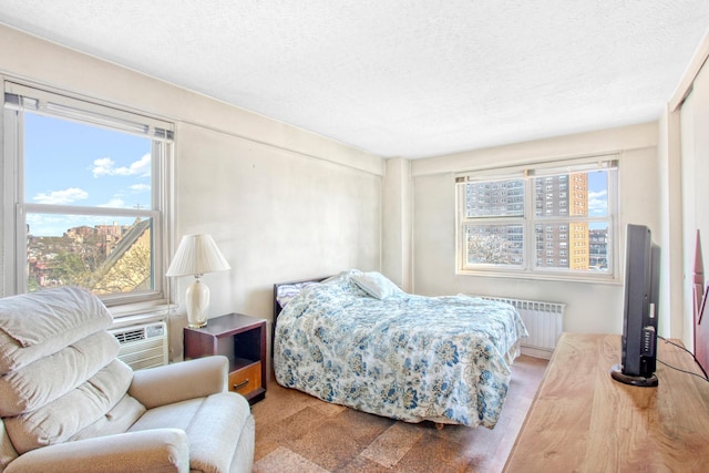 444 Neptune Ave Unit 6R, New York City, NY 11224 - bedroom featuring radiator heating unit, multiple windows, a textured ceiling, and a wall mounted AC