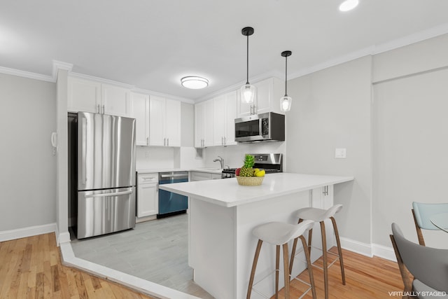 kitchen featuring stainless steel appliances, light countertops, white cabinets, and baseboards