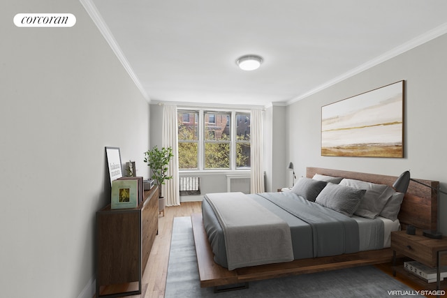 bedroom featuring visible vents, crown molding, light wood finished floors, and baseboards