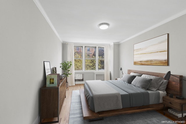 bedroom featuring ornamental molding and wood finished floors