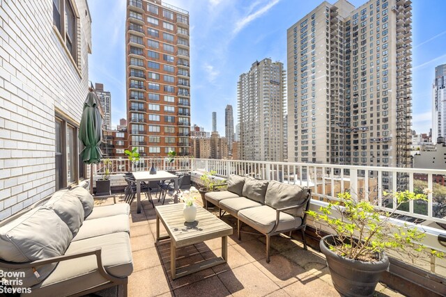 view of patio with outdoor lounge area, a city view, and outdoor dining space