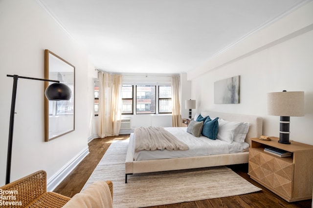 bedroom featuring dark wood-type flooring, baseboards, and crown molding