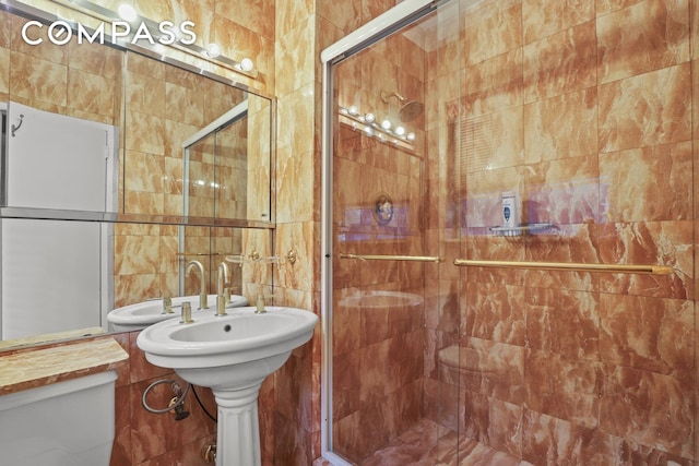 bathroom featuring a stall shower, toilet, and tile walls