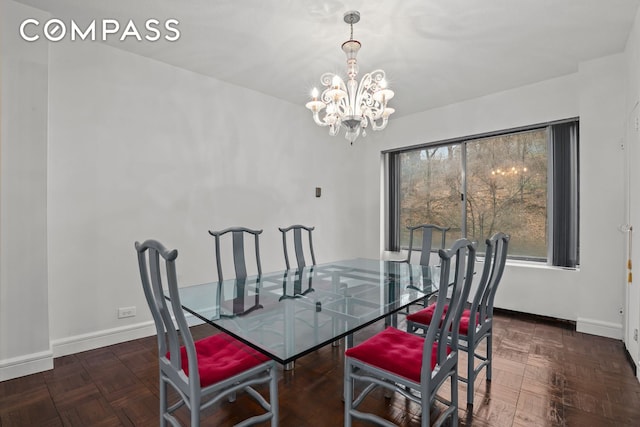 dining area featuring baseboards and a notable chandelier