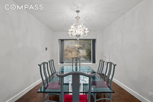 dining area featuring baseboards and an inviting chandelier