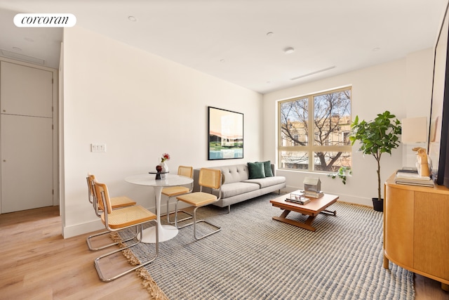 living room with baseboards, light wood-type flooring, and visible vents