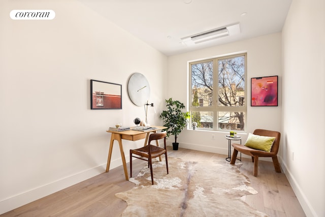 home office featuring baseboards, light wood finished floors, and visible vents