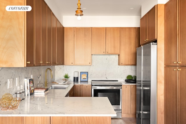 kitchen with a sink, appliances with stainless steel finishes, backsplash, and a peninsula
