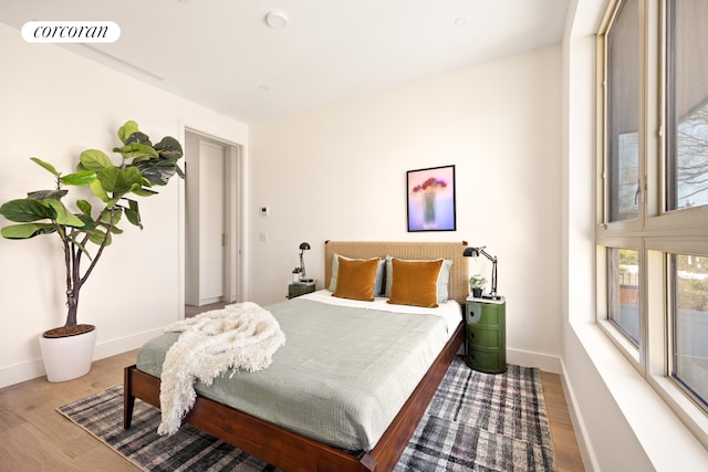 bedroom with visible vents, baseboards, and wood finished floors