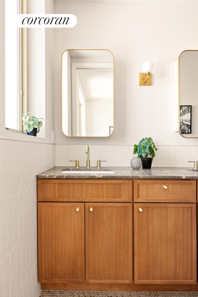 259 Rutland Rd Unit 2C, New York City, NY 11225 - full bathroom featuring tile walls, wainscoting, and double vanity