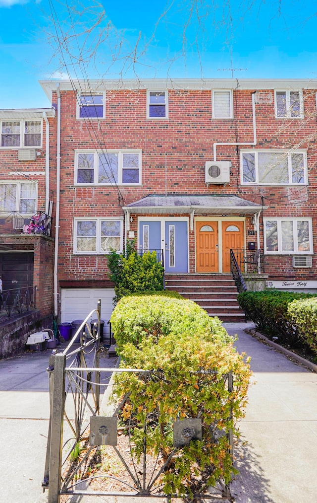 townhome / multi-family property featuring a garage, brick siding, and concrete driveway