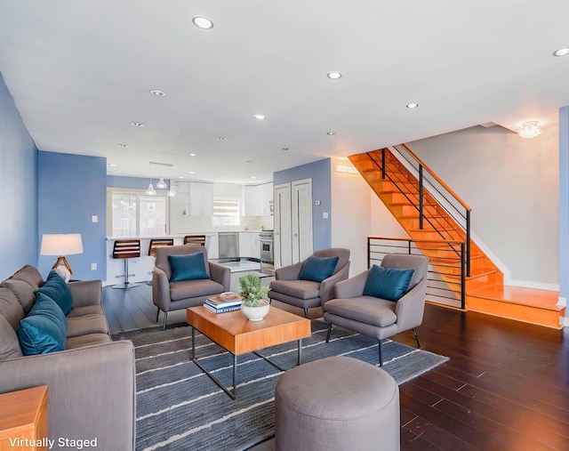 living room featuring wood-type flooring, recessed lighting, stairs, and baseboards