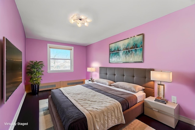 bedroom featuring wood finished floors and baseboards