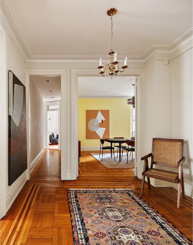 corridor with crown molding, baseboards, and a chandelier