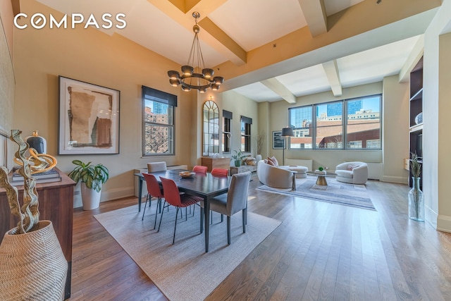 dining space with baseboards, a chandelier, beam ceiling, and wood finished floors