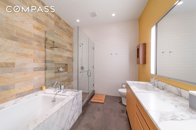 full bathroom featuring vanity, toilet, tile walls, a bath, and a stall shower
