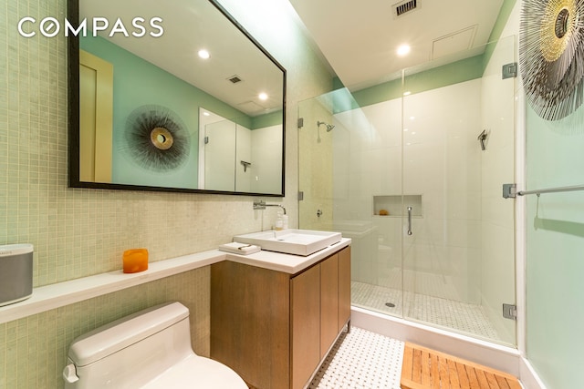 full bathroom with visible vents, tile walls, toilet, and a shower stall