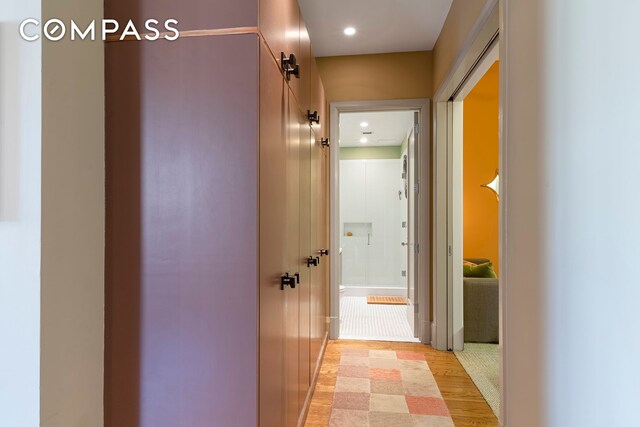 hall featuring light wood-type flooring and recessed lighting