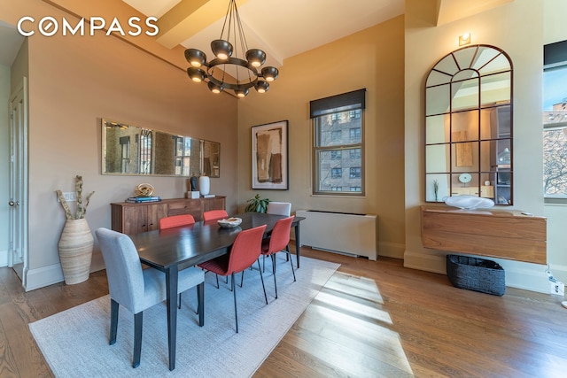 dining space with an inviting chandelier, baseboards, and wood finished floors
