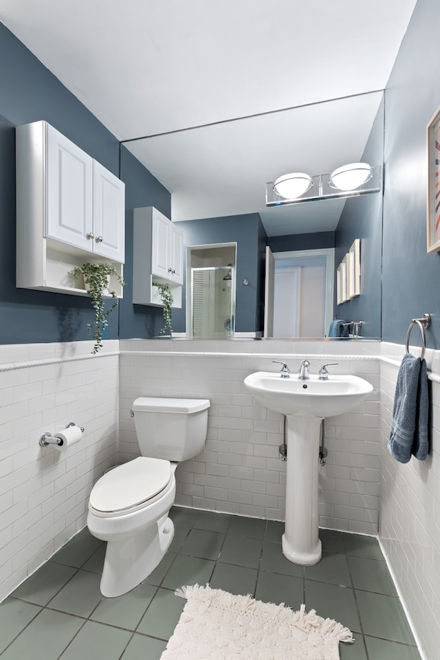 full bath with tile patterned floors, an enclosed shower, and tile walls