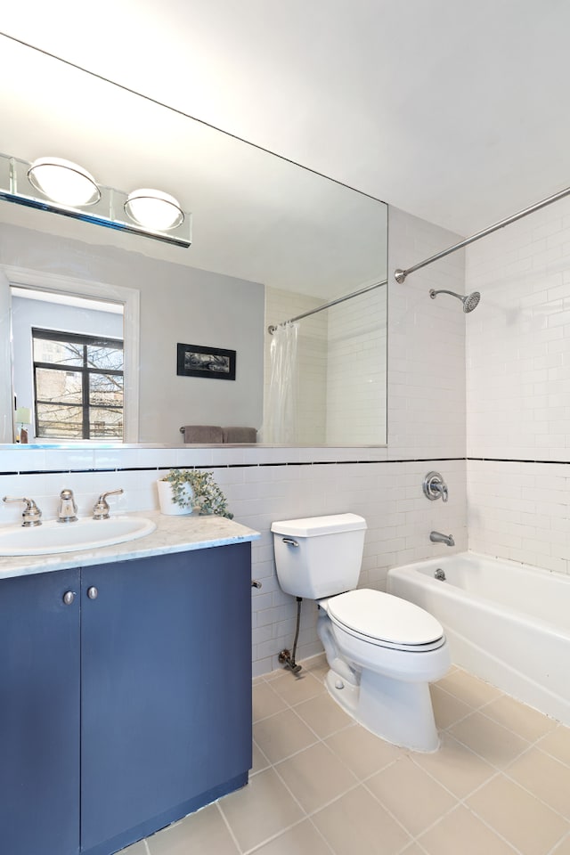 bathroom featuring tile walls, shower / bathtub combination with curtain, vanity, tile patterned floors, and toilet