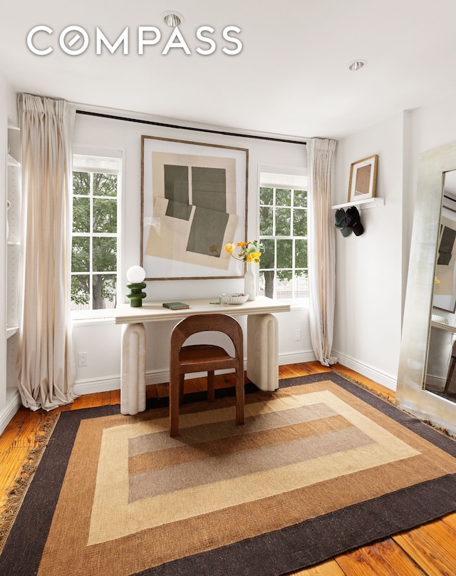 dining space with baseboards, wood finished floors, and a wealth of natural light