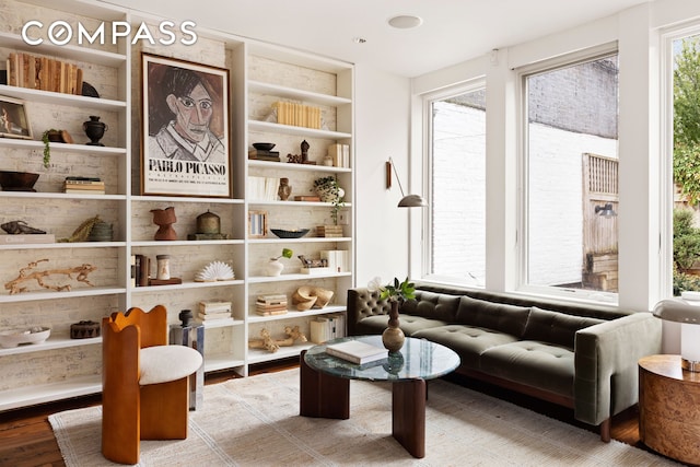 living area featuring wood finished floors and built in shelves