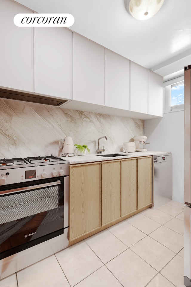 185 Park Row Unit 17F, New York City, NY 10038 - kitchen with gas range oven, light countertops, light brown cabinetry, and dishwashing machine
