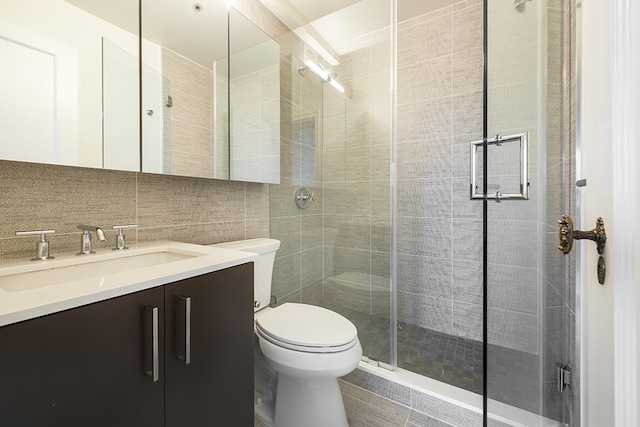 full bathroom featuring tile walls, vanity, toilet, a stall shower, and backsplash