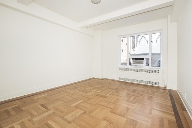 empty room featuring radiator heating unit and baseboards