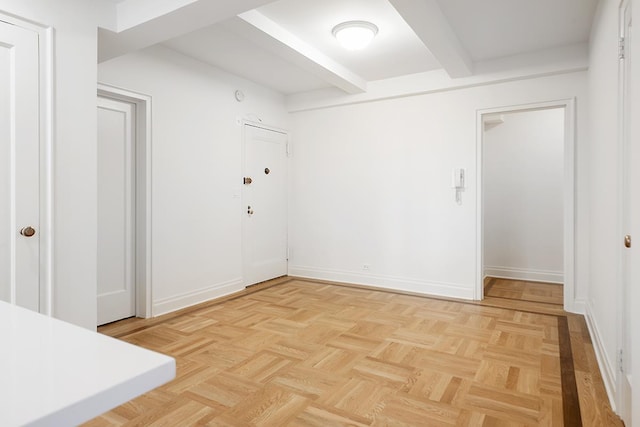 empty room featuring beam ceiling
