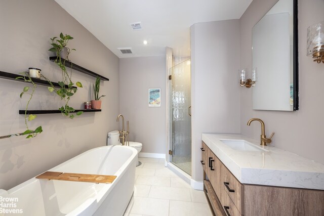 bathroom with a freestanding bath, vanity, toilet, tile patterned floors, and a shower stall
