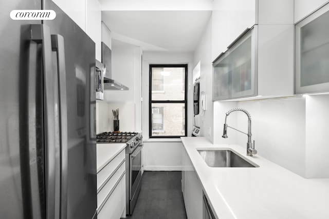 171 W 79th St Unit 56, New York City, NY 10024 - kitchen with freestanding refrigerator, stainless steel range with gas stovetop, a sink, light countertops, and white cabinetry