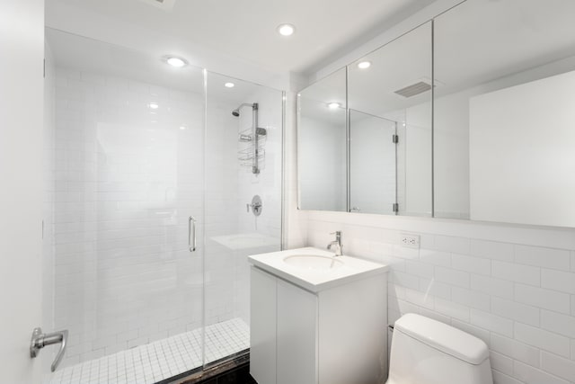 bathroom featuring recessed lighting, vanity, toilet, a stall shower, and visible vents