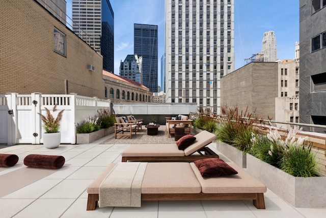 view of patio with a gate, a view of city, an outdoor hangout area, and fence