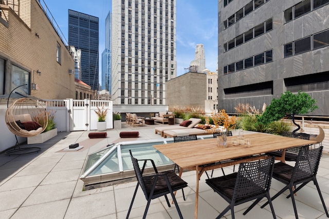 exterior space featuring a gate, fence, outdoor dining area, and a city view