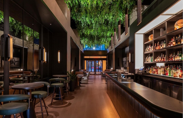indoor dry bar featuring a high ceiling and wood finished floors