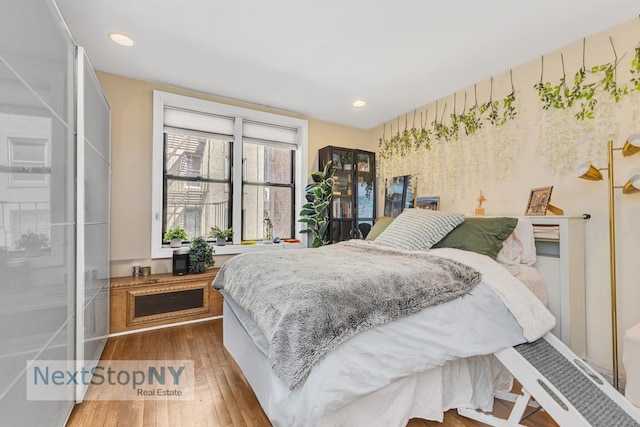 bedroom with recessed lighting and wood finished floors