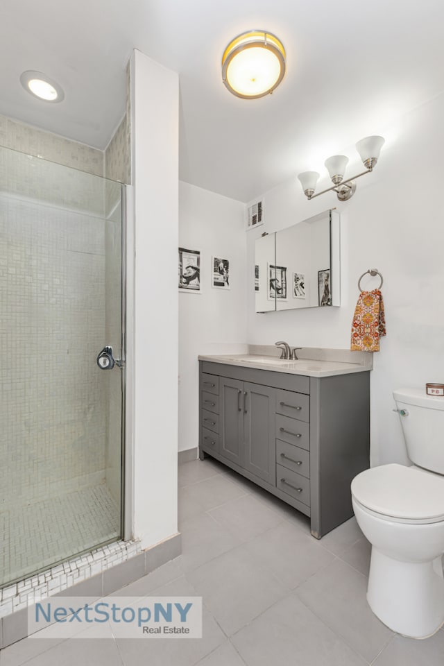bathroom featuring tile patterned flooring, toilet, vanity, visible vents, and a stall shower