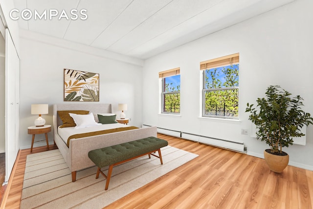 bedroom featuring a baseboard radiator and wood finished floors