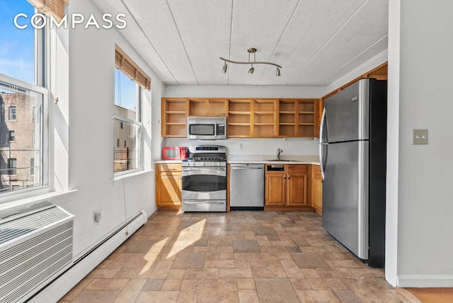 kitchen featuring appliances with stainless steel finishes, a baseboard heating unit, a sink, open shelves, and light countertops