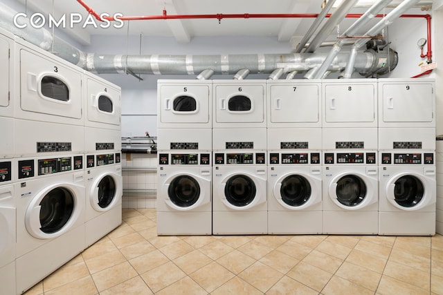 20 W 72nd St Unit 1403, New York City, NY 10023 - communal laundry room with stacked washer / dryer, washer and dryer, and light tile patterned floors