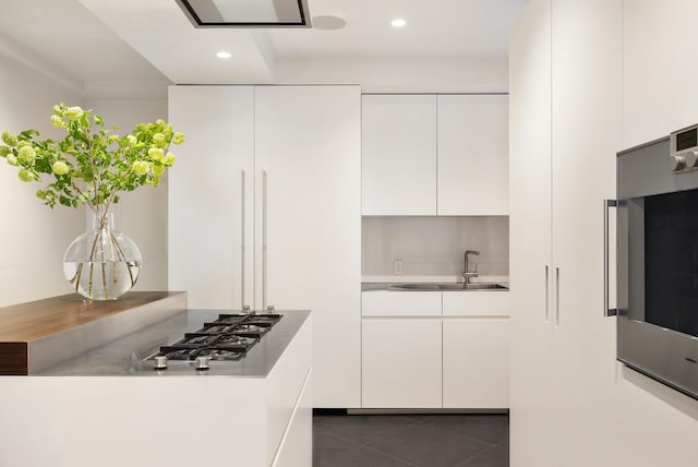 71 Park Ave Unit 10-A, New York City, NY 10016 - kitchen featuring modern cabinets, a sink, white cabinets, stainless steel gas stovetop, and dark tile patterned floors