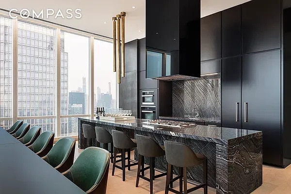 kitchen featuring dark cabinetry, a kitchen breakfast bar, a wall of windows, and modern cabinets