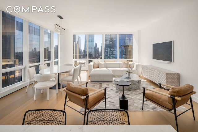 living area with floor to ceiling windows and wood finished floors