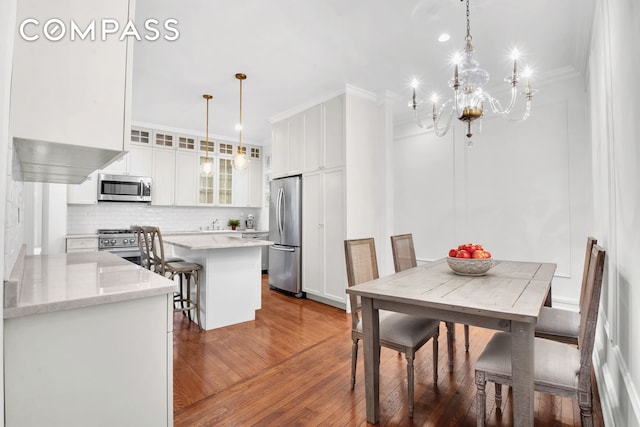 dining area featuring a chandelier, ornamental molding, and dark wood-type flooring