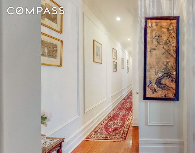 hall featuring wood-type flooring, recessed lighting, and crown molding